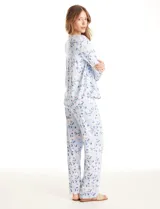 Conjunto de pijama compuesto por una remera de manga larga con escote en V, abertura frontal con botones y bolsillo aplicado, y un pantalón con cintura elástica y lazo de ajuste. Presenta un estampado animal print en tonos neutros.