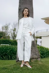 Blazer de lino blanco con solapas y detalles de volados en los puños, de corte recto y clásico.