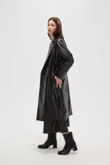 Trinchera de eco-cuero negro, con diseño de doble botonadura, solapas amplias, mangas largas y corte holgado.