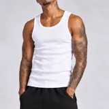 Musculosa tank blanca de corte slim y diseño acanalado, confeccionada con tejido de punto simple y versátil.