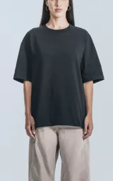 Remera de corte amplio y relajado, con hombros caídos y cuello redondo. Confeccionada en algodón premium, presenta un largo a la altura de la cadera.