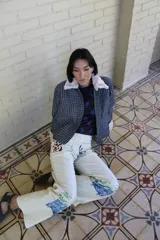 Pantalón de gabardina color crudo con estampado artístico de motivos botánicos y arquitectónicos. Presenta corte recto, tiro medio y bolsillos laterales.