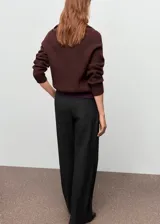 Pantalón de traje de tiro medio, diseño recto y largo, con bolsillos laterales y traseros de ribete. Cuenta con trabillas y cierre frontal con botón, gancho y cremallera.
