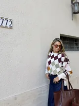 Sweater de punto con diseño de rombos multicolor en tonos bordó, verde, amarillo, rosa y crema. Presenta silueta oversize, cuello redondo y mangas largas abullonadas.
