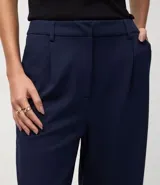 Pantalón femenino negro de punto roma, modelo recto con pliegues y sin estampado.