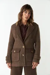 Abrigo marrón con cuello sastre, cierre frontal con botones y bolsillos con solapa.