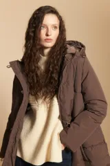 Campera acolchada de nylon color marrón, con capucha, cierre frontal y botones. Diseño capitoneado, abrigada y liviana.
