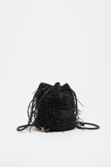 Bolso mini tipo bombonera de color marrón oscuro, confeccionado con tejido trenzado y detalles de flecos colgantes. Cuenta con cierre de cordón ajustable y correa cruzada trenzada.