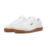 Championes Puma modelo Club 5V5, de diseño urbano inspirado en el fútbol sala. Presenta una base de cuero sintético blanco con refuerzos de gamuza en la puntera y el talón en tono beige, y una suela de goma color caramelo. Incluye el logo de la marca en dorado en el lateral y la lengüeta.