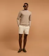 Suéter de punto color borgoña, con cuello redondo, sisas ligeramente desplazadas y bajo y puños acanalados.