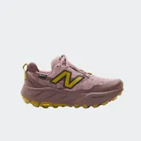 Championes de trekking New Balance modelo Fresh Foam X Hierro v9, color rosado con suela de goma amarilla y la "N" característica en tono mostaza. Incorporan entresuela Fresh Foam X y suela Vibram.