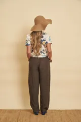 Pantalón de lino marrón oscuro, de corte ancho y relajado, con cintura elástica con cordón ajustable, bolsillos laterales amplios y botamanga recta.