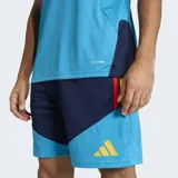 Camiseta de entrenamiento de fútbol Adidas para hombre, color celeste vibrante con textura de micro-puntos. Presenta detalles en azul marino en las mangas y hombros, con franjas en rojo y amarillo en la parte superior de los hombros. Incluye el escudo de la selección española y el logo de Adidas en amarillo.