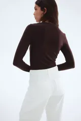 Top entallado en punto suave con escote cuadrado y mangas largas, color marrón oscuro.