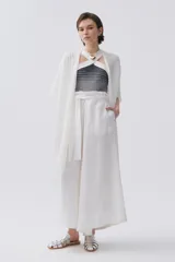 Pantalón palazzo blanco de lino con lazo en la cintura.