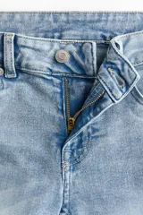 Jean de denim celeste claro con efecto desteñido, tiro bajo, corte ajustado en la parte superior y piernas acampanadas.