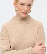 Suéter de punto texturizado con cuello alto, diseño oversized y mangas largas. Presenta una caída amplia y una superficie encorpada, ideal para un estilo moderno y acogedor.
