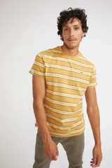 Remera de hombre de manga corta y cuello redondo, con diseño de rayas horizontales en tonos mostaza, blanco y negro. Presenta un ajuste regular y logo pequeño estampado en el pecho.