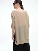 Sweater tipo túnica de tejido liviano con hilo brillante, de corte amplio y holgado. Presenta escote en V, mangas largas y una textura con transparencia sutil.