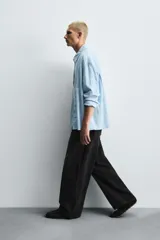 Jeans de denim de algodón, color azul oscuro con efecto lavado. Presentan un corte muy holgado (baggy fit) en toda la pierna y tiro medio. Tienen cinco bolsillos y cierre frontal con cremallera y botón.