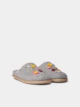 Pantuflas de fieltro color gris, abiertas en el talón, con delicados bordados florales multicolores en el empeine y detalle de trenza de yute en la suela.