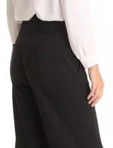 Pantalón de vestir color marrón, de corte wide leg y tiro alto. Presenta una cintura ancha con detalles de hebillas y botones decorativos en tono dorado, además de bolsillos laterales funcionales.