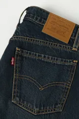 Jeans de denim azul oscuro con lavado vintage, tiro alto y corte acampanado.