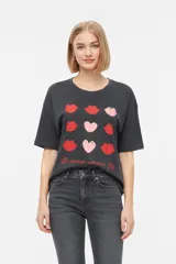 Remera marrón de manga corta con cuello redondo y diseño holgado. En el frente presenta una estampa en tono verde claro con forma de corazón, estrellas y la frase 'You are my lucky'.