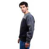 Buzo Volcom de cuello redondo en combinación de colores gris y negro, con diseño en bloques y el logo de la marca bordado en el pecho.