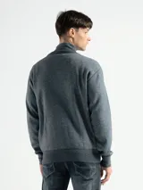 Campera de punto color gris con cierre frontal metálico y cuello alto, forrada en polar.