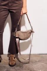 Bandolera marrón de gamuza sintética con cierre superior, correa de mano de cadena plateada y correa bandolera ancha de tela.