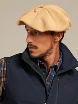 Boina azul marino de paño con visera pequeña y botón decorativo en la parte superior.