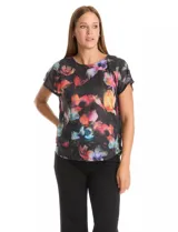 Remera de manga corta con frente estampado con diseño floral multicolor sobre fondo negro y espalda lisa. Presenta cuello redondo a la base y corte recto.