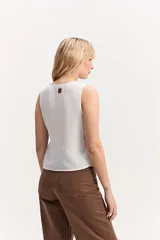 Chaleco cruzado blanco de textura acanalada, con escote en V y ajuste mediante lazo lateral.