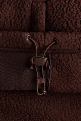 Campera deportiva de sherpa marrón con cuello elevado, cierre frontal y bolsillos laterales.