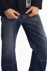 Pantalón de jean azul oscuro de corte recto, con refuerzos en las rodillas y bolsillos laterales. Diseño de estilo cargo con frente reforzado.
