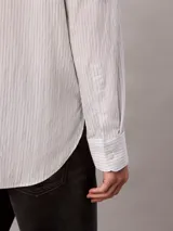 Camisa de manga larga Calvin Klein con diseño de rayas finas verticales, cuello camisero y cierre frontal de botones.
