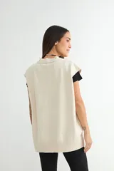 Chaleco de punto color verde, con escote en V y cierre frontal de botones negros. Presenta un diseño holgado con terminaciones acanaladas en el cuello, sisas y ruedo.