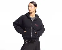 Campera negra de algodón con cierre frontal, capucha, bolsillos laterales y detalles de tachas metálicas en la capucha y los bolsillos. Presenta un estampado frontal con texto en tono rojizo.