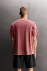 Camiseta de algodón con efecto lavado, cuello redondo y manga corta. Presenta un estampado gráfico a tono en la parte frontal.