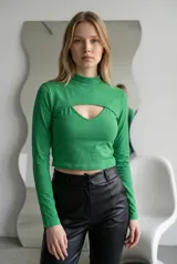 Top de manga larga color verde, confeccionado en tejido elástico. Presenta un diseño de dos piezas con cuello alto y una abertura frontal tipo cut-out en el pecho.