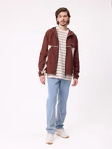 Rompevientos Rusty con capucha, diseño bicolor en azul marino y gris, cierre frontal y logo bordado en el pecho.