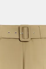 Pantalón de tiro alto con pierna ancha, diseño con pliegues frontales y cinturón integrado del mismo tejido con hebilla forrada. Cuenta con cierre lateral mediante cremallera oculta.
