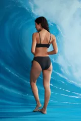 Conjunto de bikini negro de dos piezas con corpiño de escote cuadrado y tirantes finos, y bombacha vedetina con tiras laterales ajustables.