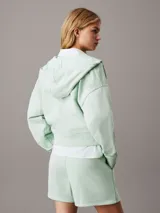 Buzo con capucha y cierre de cremallera color verde claro.