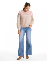 Buzo tejido de punto en color beige, con diseño nórdico geométrico en tonos rosa y blanco alrededor del canesú. Presenta cuello redondo a la base, mangas largas con puños elásticos y ruedo acanalado.