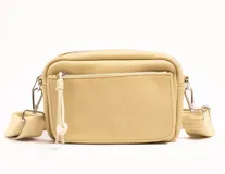 Bandolera color beige con correa ancha regulable y bolsillo externo.
