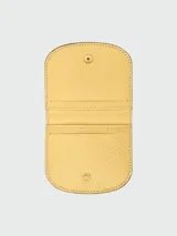 Tarjetero amarillo de cuero texturizado con cierre de broche a presión dorado con el logo de la marca.