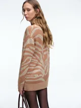 Cardigan de punto con escote en V y cierre frontal de botones. Presenta un diseño estampado de animal print con acabado brillante, mangas largas y corte holgado.