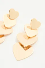 Aros largos de metal plateado con diseño de tres corazones colgantes de tamaño decreciente.